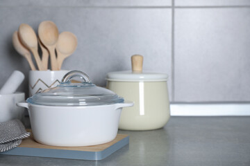 Cooking utensils and other kitchenware on grey countertop. Space for text