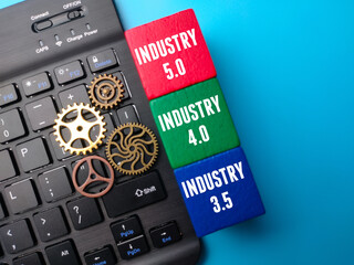 Wireless keyboard and colored wooden cube with the word Industry 5.0,40,3.5 on blue background.