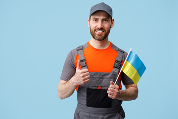 Smiling Worker employee man in uniform holding ukrainian national flag in hand