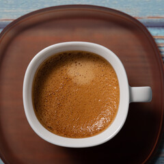 Brown espresso coffee served on a white cup close up still