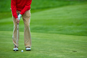 Fototapeta premium man in red playing golf, active recreation concept