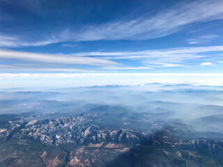 A beautiful view from the airplane window to the skies, mountains and plains