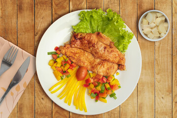 Grille de pollo con lechuga y pimentón dulce picado con tomate cherri