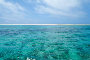 Fototapeta na wymiar サンゴ礁の海越しに見える はての浜の陸地