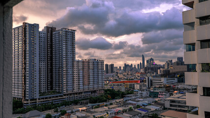 Naklejka premium The high angle background of the city view with the secret light of the evening, blurring of night lights, showing the distribution of condominiums, dense homes in the capital community