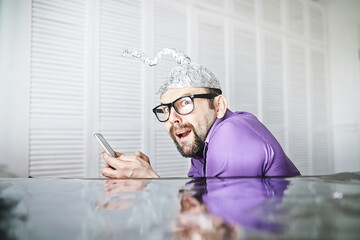 Bearded funny man in a cap of aluminum foil. Concept art phobias.Conspiracy theory. Conspiracy....