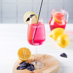 Refreshing summer drink in a glass, red basil lemonade.