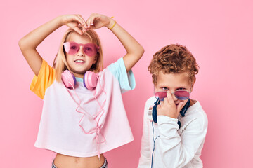 trendy boy and girl wearing headphones posing casual kids fashion