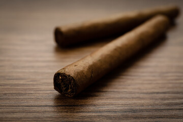 Cigars wrapped in tobacco leaves on wooden table, closeup