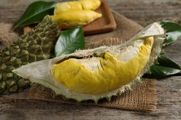 Pieces of fresh ripe durian fruit on wooden table, closeup