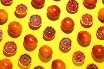 Many ripe sicilian oranges on yellow background, flat lay