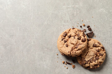 Two delicious chocolate chip cookies on grey marble table, top view. Space for text