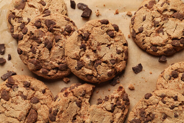 Delicious chocolate chip cookies on parchment paper, flat lay