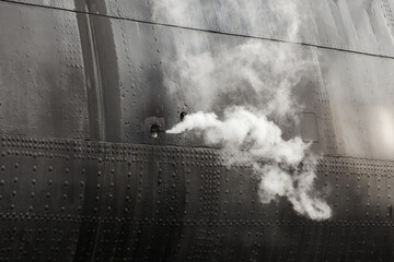 Steam goes out of black vintage ship hull