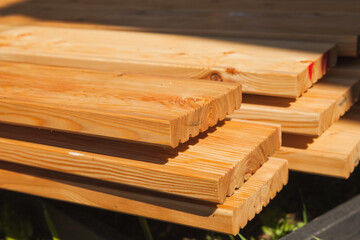 Stacked larch deck boards, close up outdoor photo