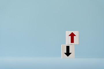 Up and down turn arrow on wooden blocks difference direction to earn or to loss. Red arrow as...