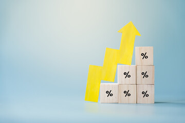 Yellow paper cut arrow going up positive trend on wooden blocks with percentages. Concept of profit...