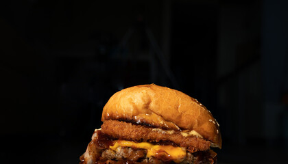 Tasty grilled burger with with beef, cheese, vegetables. Delicious grilled Cheeseburger on a dark background.