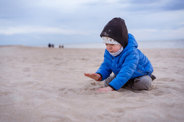Child, toddler, little boy playing in the sandy Baltic sea beach. Family vacation and lifestyle...