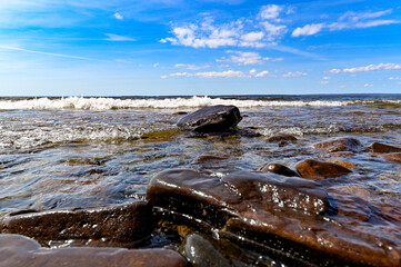 low perspective of wave over stone on beach