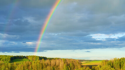 A real double rainbow in a cloudy sky after heavy rain. A rare natural phenomenon in the blue sky....