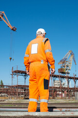Shipyard worker in overalls, rear view