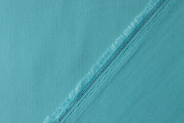 Light blue fabric with fringe and seam closeup