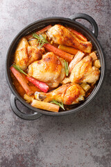 Chicken with rhubarb, onions and garlic are simmered with white wine and butter into a rich sauce close-up in a frying pan on the table. vertical top view from above