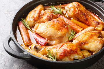 Delicious chicken braised and then baked with rhubarb, rosemary and white wine close-up in a frying pan on the table. horizontal