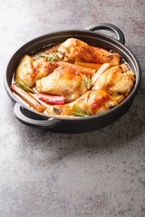 Chicken with rhubarb, onions and garlic are simmered with white wine and butter into a rich sauce close-up in a frying pan on the table. vertical