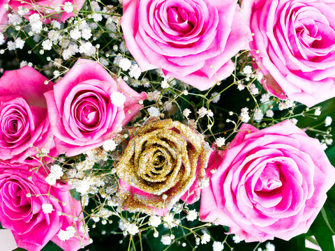 Bright pink and golden roses flower bouquet top view close up, natural festive pattern