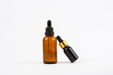 two bottles of facial oil on a white background