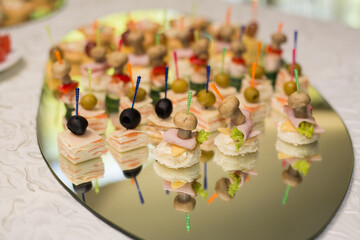 Appetizing canapes on skewers on a buffet table