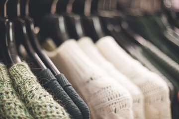 Many wooden plastic racks hangers with denim clothes male fashion dressing outfit in a shopping mall photo with selective focus. Making choice in a market.