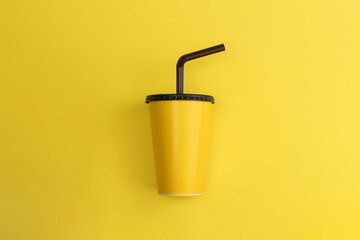 Yellow paper glass with brown lid on yellow background