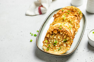 Zucchini fritters with sour cream. Top view, copy space, flat lay.