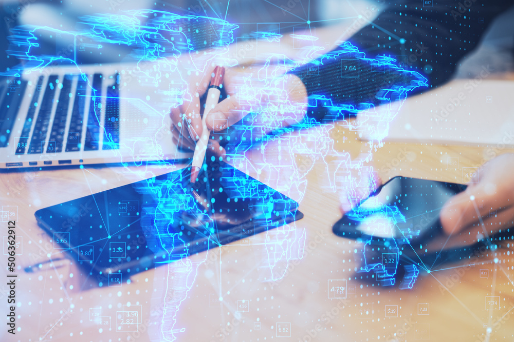 Poster hands using digital tablet with pen and smartphone with glowing blue map hologram and digital data concept on blurry office desktop background. Info, news and planet concept. Double exposure.