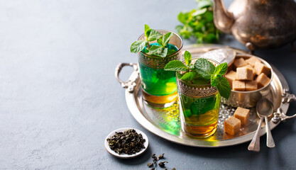 Moroccan mint tea in glasses with sugar on silver tray. Copy space.