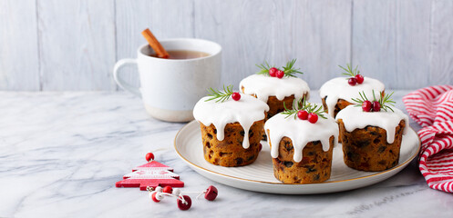 Christmas puddihgs, cakes with tea. Traditional dessert. Marble table. Grey background. Copy space.
