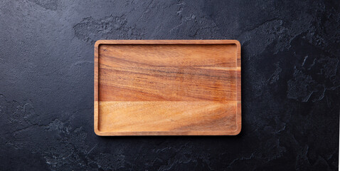 Wooden tray, cutting board. Dark background. Copy space. Top view.