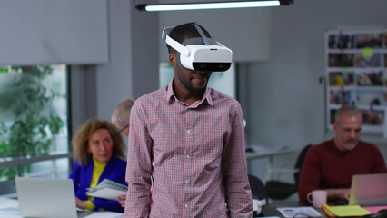 African-American businessman using virtual reality headset in office