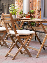 Summer terrace of restaurant. Cafe with wooden tables and chairs on the street. Restaurant furniture