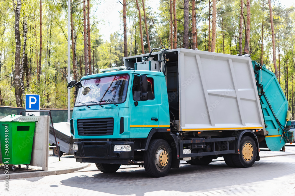 Leinwandbilder A garbage truck picks up garbage in a residential area. Loading mussar in containers into the car. Separate collection and disposal of garbage. Garbage collection vehicle.