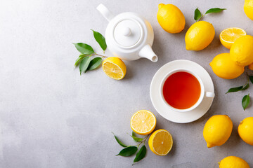 Obraz na płótnie Canvas Tea cup and pot with lemon. Grey background. Copy space. Top view.