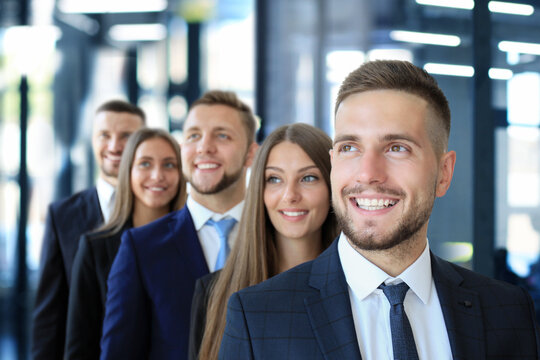 Happy smiling business team standing in a row at office