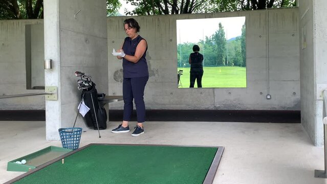 Golfer Preparation to Practicing Golf Swing in Driving Range with a Mirror on the Wall in Switzerland.