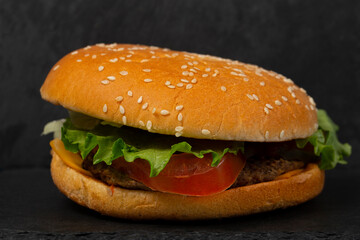 Classic hamburger close-up on a black background.