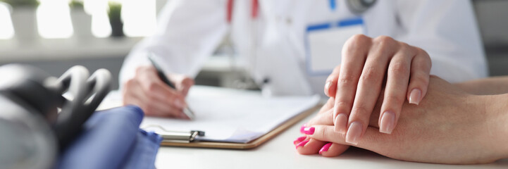 Female doctor holding the patient's hand, close-up