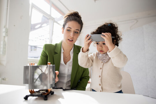 Mother and daughter exploring high-tech development the metaverse using virtual reality simulator