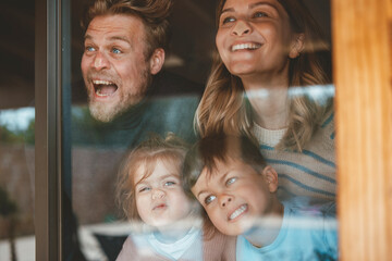 Parents and children pressing faces on window glass